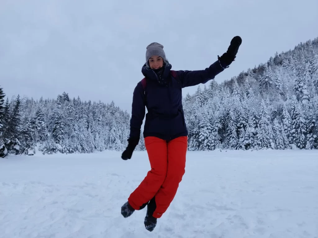 person jumping on frozen lake spruce