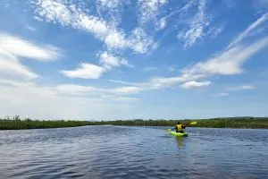 a girl on a kayak in the middle of a lake