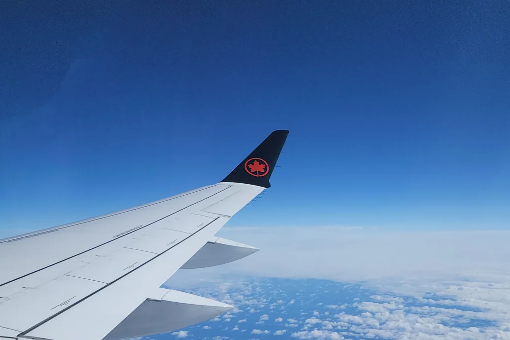 the view from an airplane window of a plane wing above the clouds