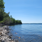 a lakeshore on the lake champlain with rocks a trees